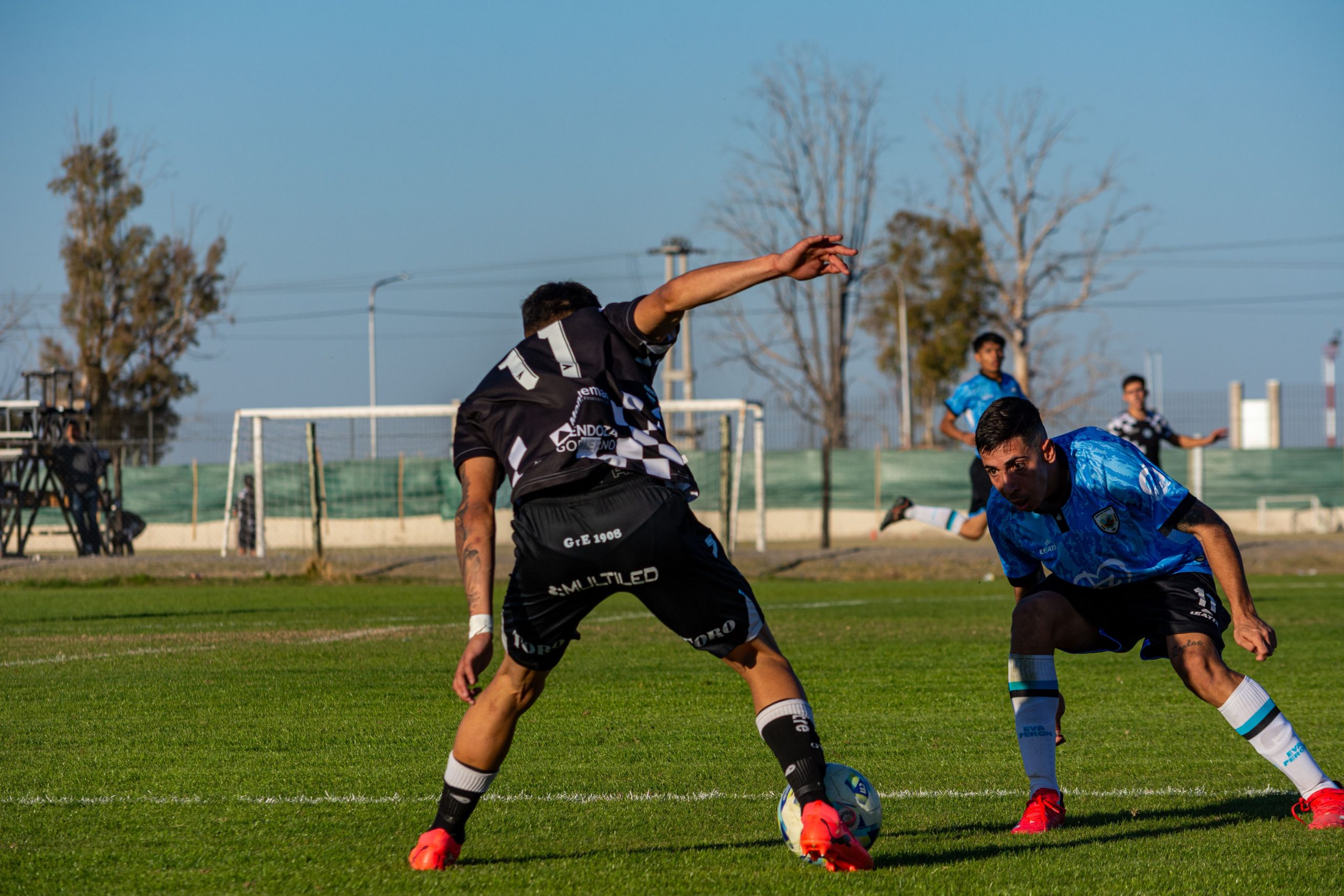 Football players challenging for the ball near the touchline, a moment that often leads to a corner in corners betting